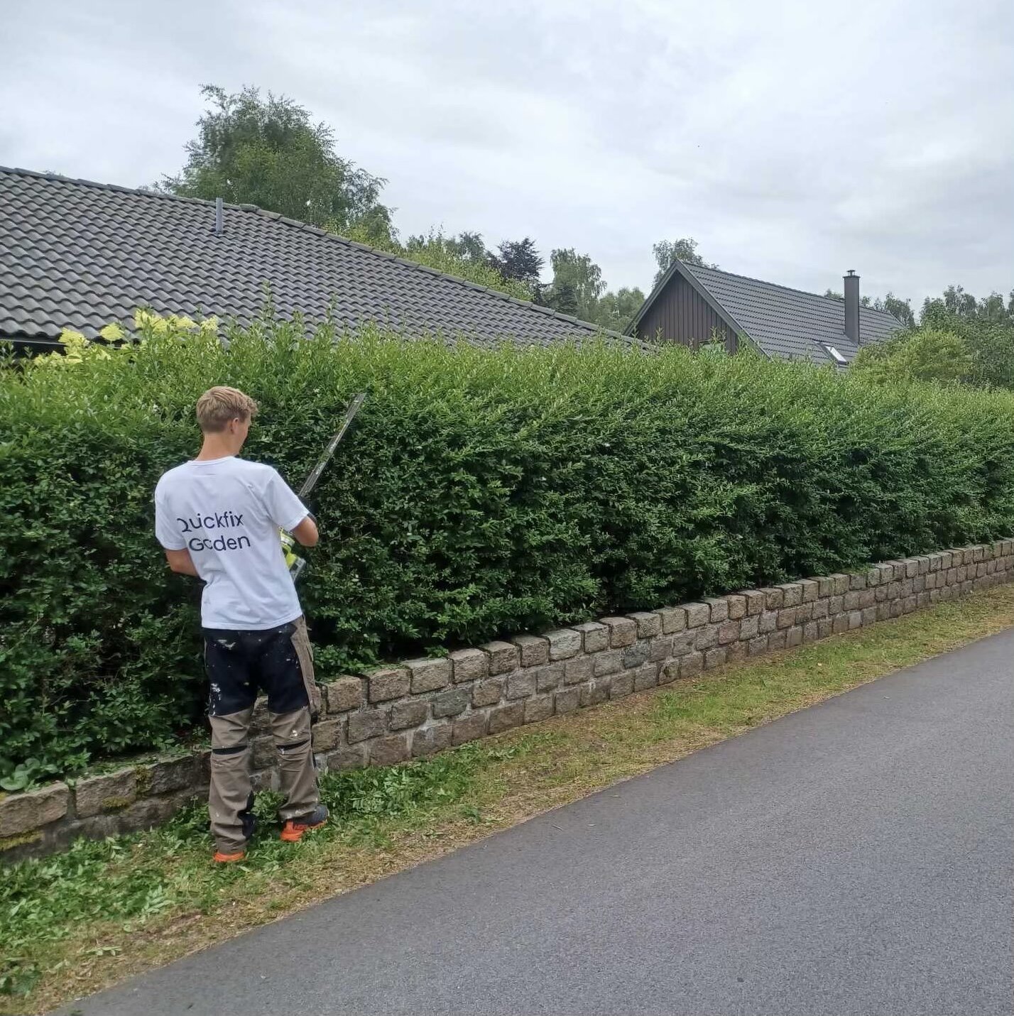 Oskar i Quickfix Garden-tröja klipper häck